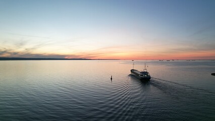 Obraz premium Cargo ship on the background of the fiery sunset of the Baltic Sea.