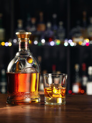 close up view of bottle of whiskey and glass aside on color back. 