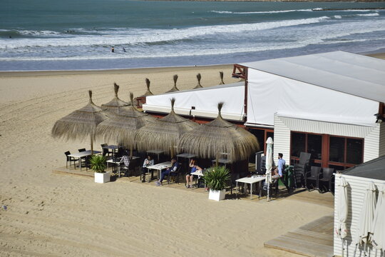 Cadiz, Spain - 06 november 2019: Cafe with umbrellas on the city beach