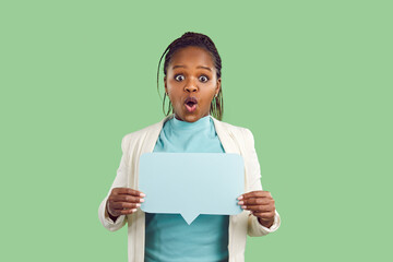 Black woman holding mock up copyspace speech bubble on color studio background. Afro American lady reacts to interesting message, web news, or dialogue with funny surprised excited face expression