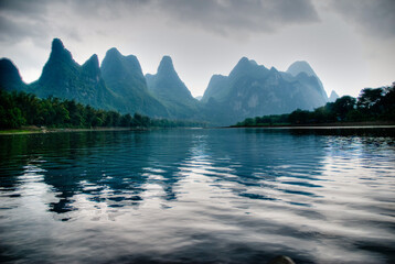 Reflective sunset view of the Li River on the Yangshuo River in Guilin China - obrazy, fototapety, plakaty