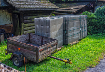 Building materials – concrete blocks and wheelbarrow in the yard of country house