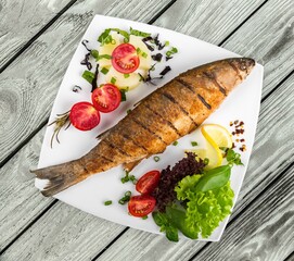 fried fish fillets on a plate on a wooden table
