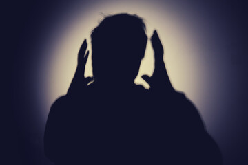 Shadow of a man from the night light of a flashlight on a white wall. Silhouette of a man head from...