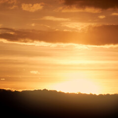 Dark clouds in the evening sunset sky with the setting sun. Dramatic sky during orange sunset