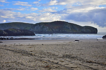Sandy beach at the rocky coast of the ocean . The Way of St. James, Northern Route, Spain