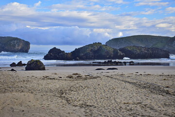 Fototapeta na wymiar Sandy beach at the rocky coast of the ocean . The Way of St. James, Northern Route, Spain