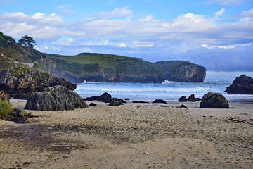 Fototapeta na wymiar Sandy beach at the rocky coast of the ocean . The Way of St. James, Northern Route, Spain