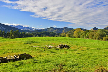 Fototapeta na wymiar View of the rural landscape against the background of mountains and blue sky . The Way of St. James, Northern Route