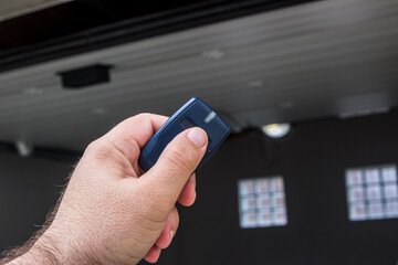Garage door PVC. Hand use remote controller for closing and opening garage door
