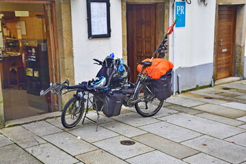 Santiago de Compostela, Spain. A loaded pilgrim's bicycle near the building.