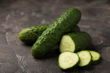 Fresh organic cucumbers whole and slices on wooden texture background.Ingredient for salad.Fresh vegetables.Vegan food.Healthy food.Fresh organic vegetable.Copy space.