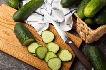 Fresh organic cucumbers whole and slices on wooden texture background.Ingredient for salad.Fresh vegetables.Vegan food.Healthy food.Fresh organic vegetable.Copy space.