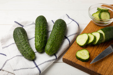 Fresh organic cucumbers whole and slices on wooden texture background.Ingredient for salad.Fresh vegetables.Vegan food.Healthy food.Fresh organic vegetable.Copy space.