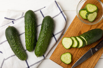 Fresh organic cucumbers whole and slices on wooden texture background.Ingredient for salad.Fresh vegetables.Vegan food.Healthy food.Fresh organic vegetable.Copy space.