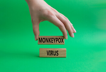 Monkeypox virus symbol. Concept word Monkeypox virus on wooden blocks. Beautiful green background. Doctor Hand. Medicine and Monkeypox virus concept. Copy space