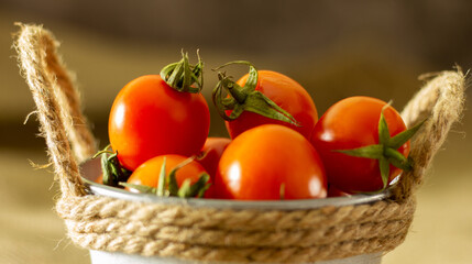 Bucket with red tomatoes on jute