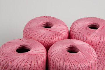 Spools of pink thread on a gray background. Photo for a banner.