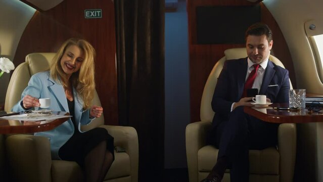Business class passengers flying corporate jet. Successful partners resting