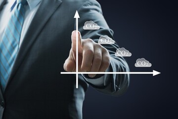 Business man's hand raising amount of CO2 emissions graph concept