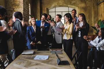 Diverse business people celebrating together inside bank office - Focus on center man face