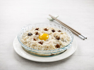 Stewed Vermicelli topped with Shredded Fish and Conpoy served in a dish side view on grey background