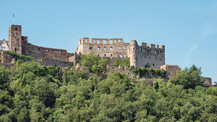 Fototapeta premium The ruins of a castle look down from the hills along the Rhine river in Germany.