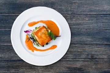 fried fish fillets on a plate on a wooden table