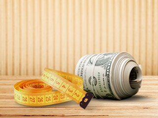 The tape measure tightly bound the $100 bill. Currency devaluation, economic crisis, rising prices,...