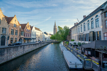 Obraz premium Canal in Bruges and Belfry tower - Houses and Streets - Bruges, Belgium - the city centre
