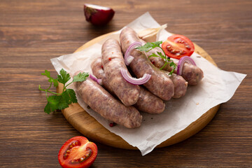 Raw barbeque wurst sausage on wooden surface