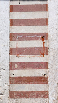 Pared pintada con rayas blancas y rojas en antiguo taller mecánico abandonado