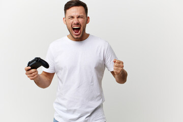 Aggressive angry tanned handsome man in basic t-shirt play difficult game with joystick gamepad...