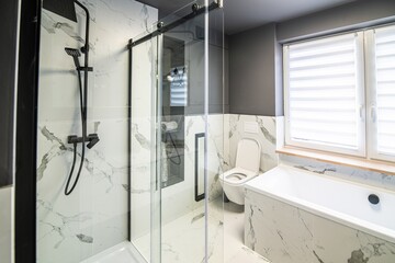 Modern flat bathroom with grey walls and white bath and shower cabin