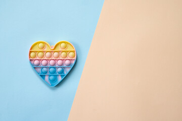 Trendy toy antistress, pop it on a rainbow background, fidget toy, top view
