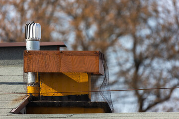 Ventilation equipment  on the roof of the building against blurry background. Chimneys covered with...