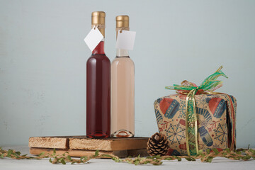 Christmas wine and present box. Two bottles of red and pink wine, no brand, mock up on wooden...