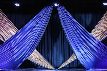 Bright braided front curtains in the blue and silver colors of a stage, in the background another...