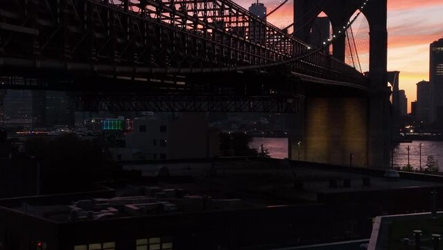 rising alongside Brooklyn Bridge revealing downtown NYC sunset