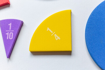 Bue and yellow pieces of fractions on the table. Close up math material for study. Back to school, geometry lessons, mathematical education for preschooler. Creative study