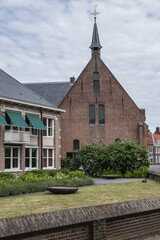 Fototapeta na wymiar Intimate Chapel from 1390 with its beautiful arched windows and men's hall (Mannenzaal) behind it - remained from medieval building of St. Pieters en Bloklands Gasthuis. Amersfoort, the Netherlands.