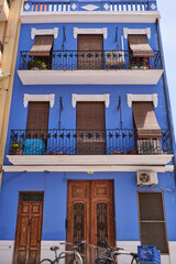 Facade of a beautiful blue color apartment building with wooden shade and balconies in a popular El Cabanyal (Cabanyal-Canyamelar) neighbourhood in Valencia, Spain, which is part of the sea village.