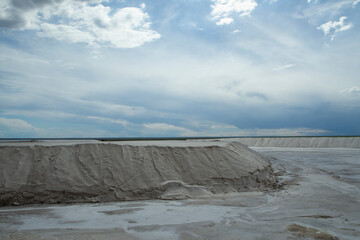 Industrial. View of the natural white salt flats and open cast mining pit under a dramatic sky.	
