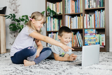 Children watch lessons through a laptop and make online calls. Social media and the use of technology by children. Study at home online