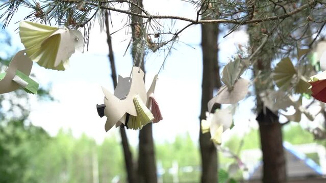 Paper doves hang on branches - a symbol of peace