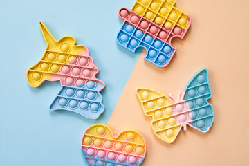 Rainbow pop it fidget toys on color background, flat lay.  - obrazy, fototapety, plakaty