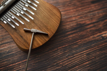 Top view of the kalimba and tuning hammer. Kalimba is a musical instrument with a wooden soundboard and metal keys.