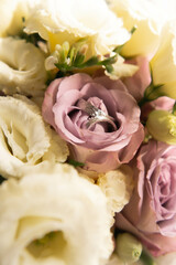 bridal bouquet with roses and eustoma. Wedding rings.