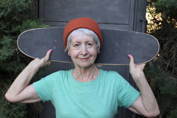 Cool looking senior woman holding a skateboard