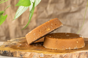 Colombian panela or sugar cane candy, ready to be consumed in various typical dishes. piloncillo ready for sale and marketing, placed on a wooden board and surrounded by green leaves.